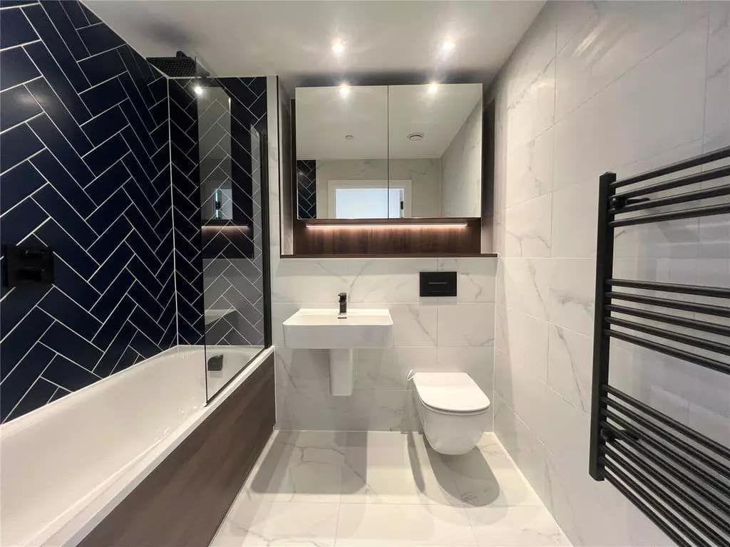 A bright navy and marble family bathroom built in South London
