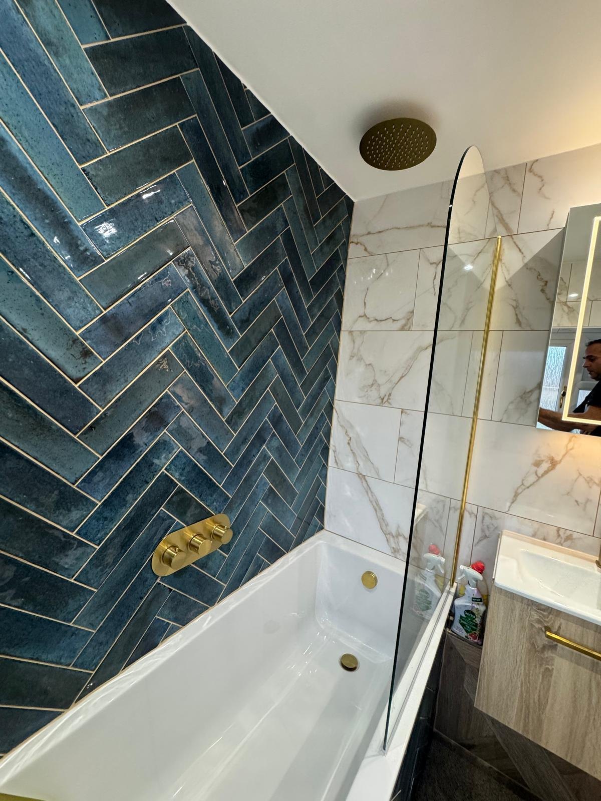 A luxury bathroom with teal tiling and gold fittings