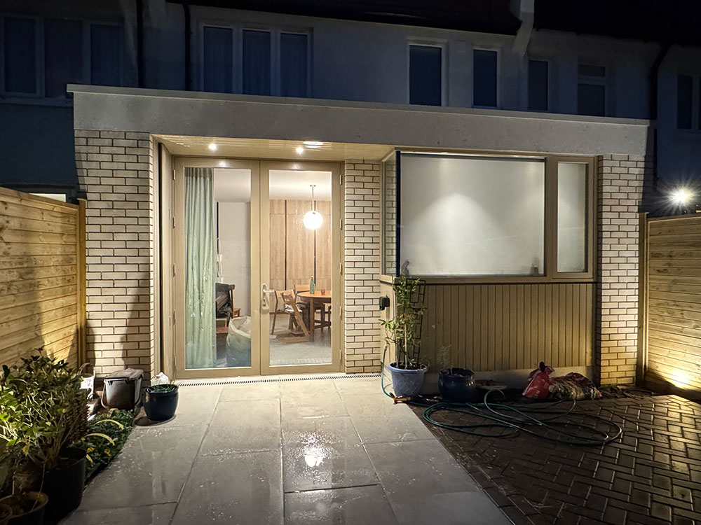 A rear extension lit at dusk by Professional Polish Builders in Croydon & South London